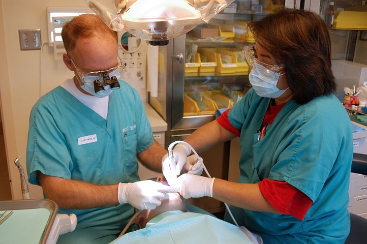 Two dentists checking a patient