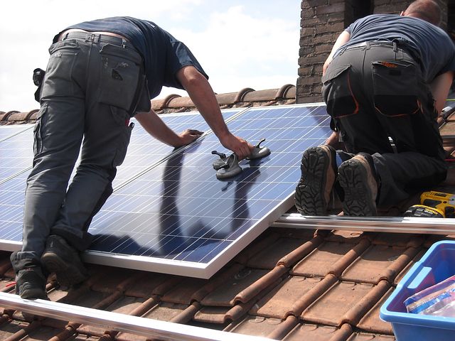 Two men installing commercial solar panels
